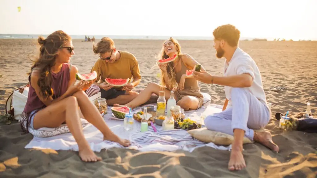 People on the beach in Santa Monica picnicking with a picnic provided by the Sandbourne Santa Monica