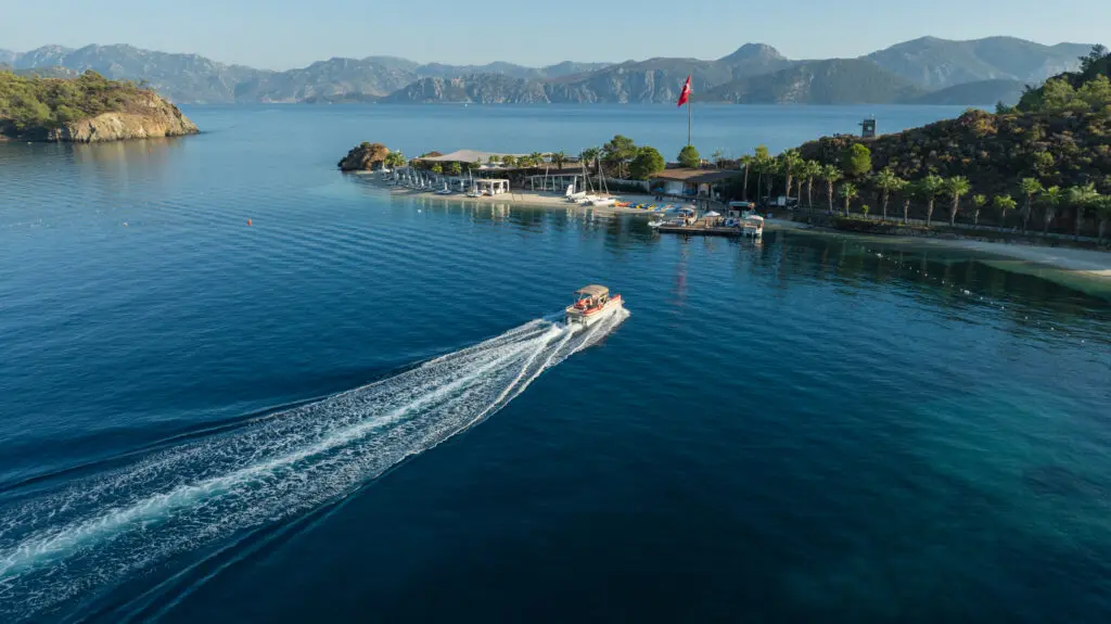 A boat plying through the water toward the marina at D Maris Bay