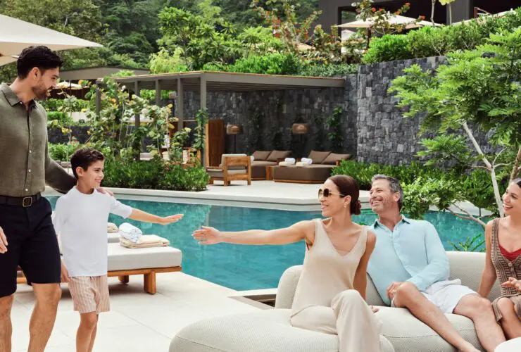 A multigenerational family sitting by the pool at Waldorf Astoria Costa Rica Punta Cacique