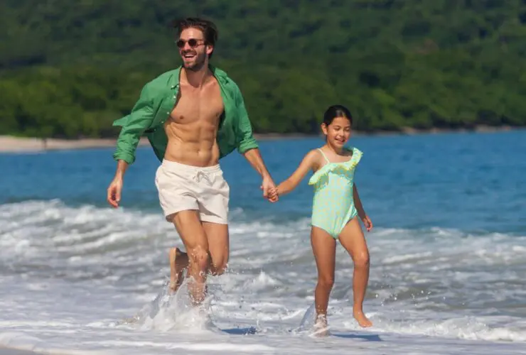 A parent and child on the beach at The Westin Reserva Conchal