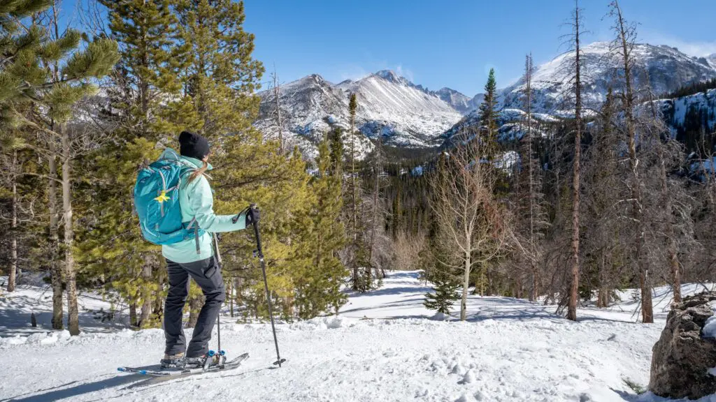 Seorang wanita bermain sepatu salju di kawasan Estes Park