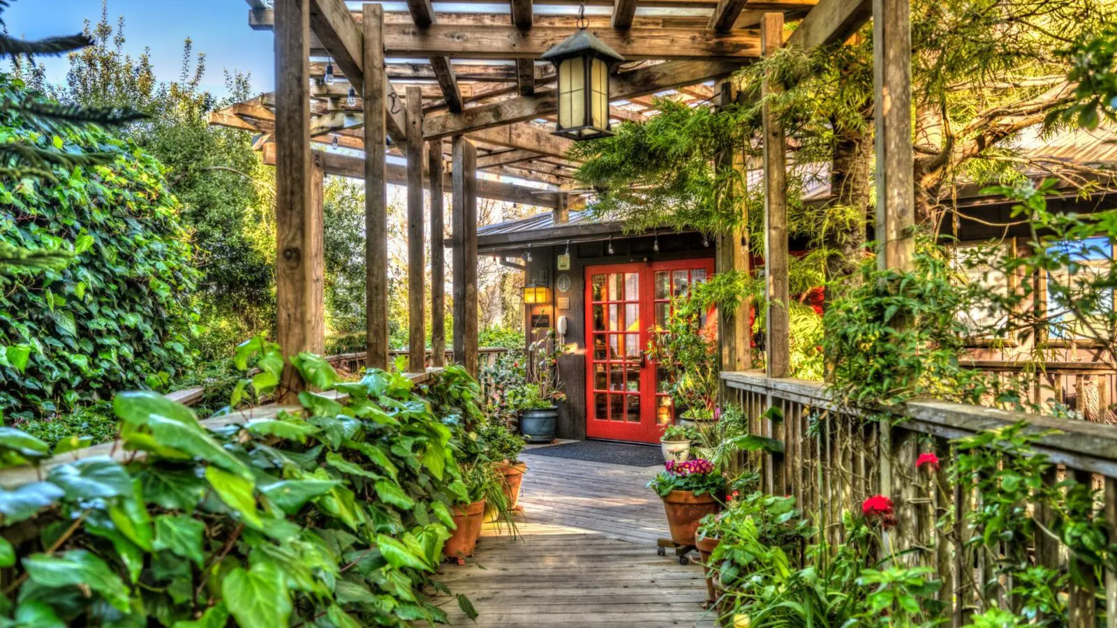 Stanford Inn walkway with lush gardens and red door