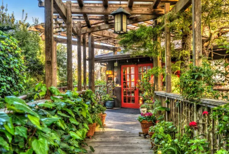 Stanford Inn walkway with lush gardens and red door