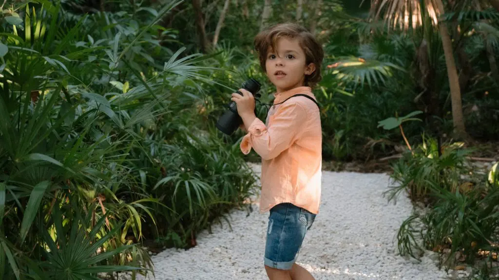 A little boy with binoculars exploring the landscape around Conrad Tulum Riviera Maya