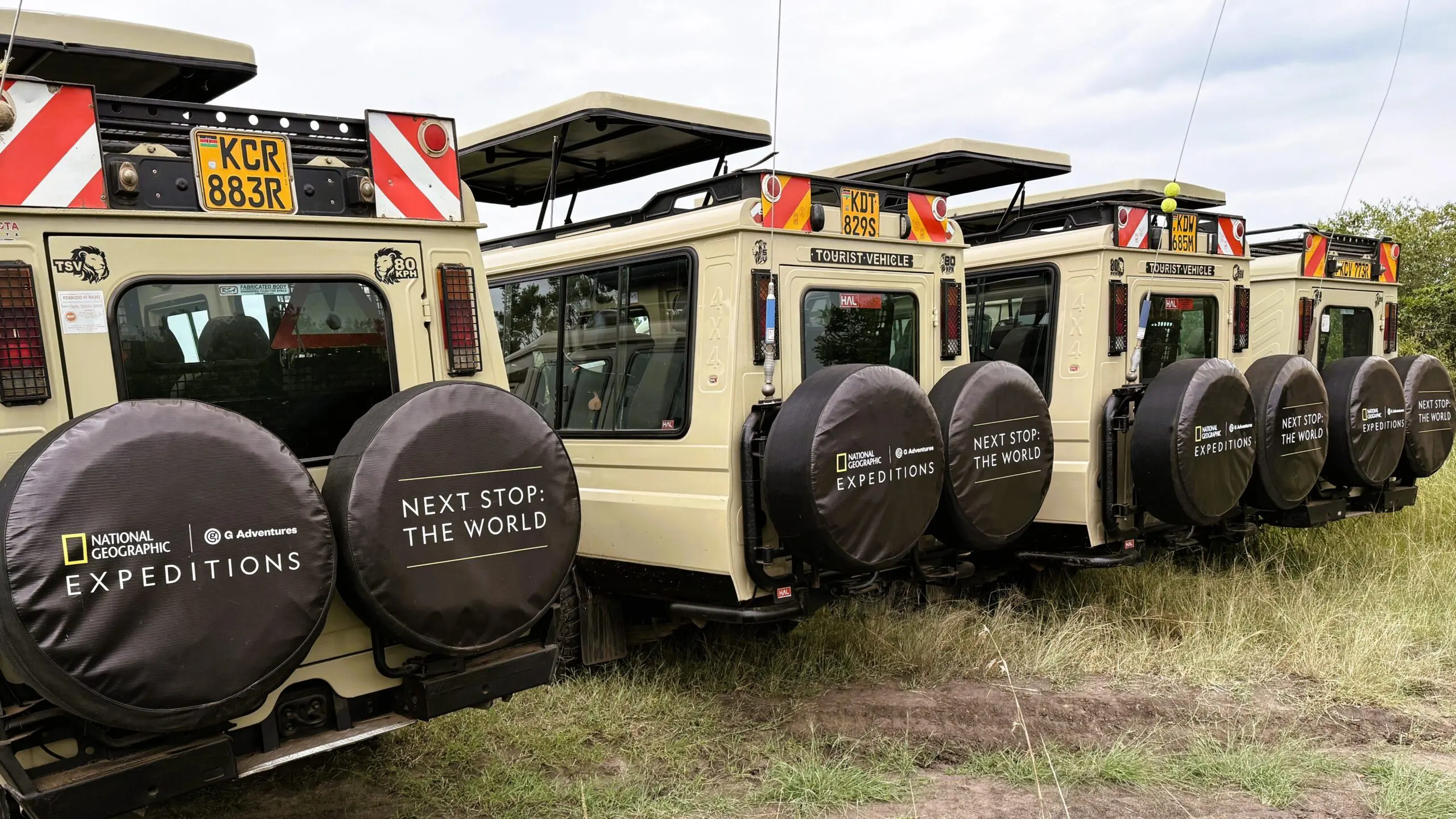 Four National Geographic Expeditions safari vehicles lined up in Africa