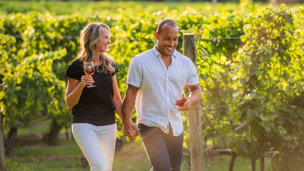 A couple walking through a vineyard in Traverse City, MI