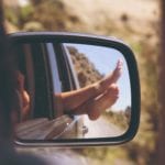 Feet out the window of car (Photo by anja. on Unsplash)