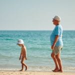 Child and grandparent on beach (Photo by Vidar Nordli-Mathisen on Unsplash)