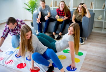Family playing classic board game Twister (Photo: Elena Nichizhenova/Shutterstock)