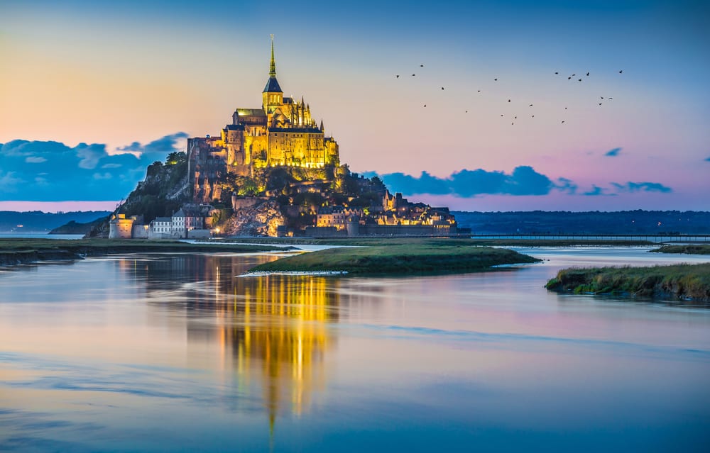 Panoramic view of famous Le Mont Saint-Michel tidal island in beautiful twilight during blue hour at dusk, Normandy, northern France (Photo: Shutterstock)