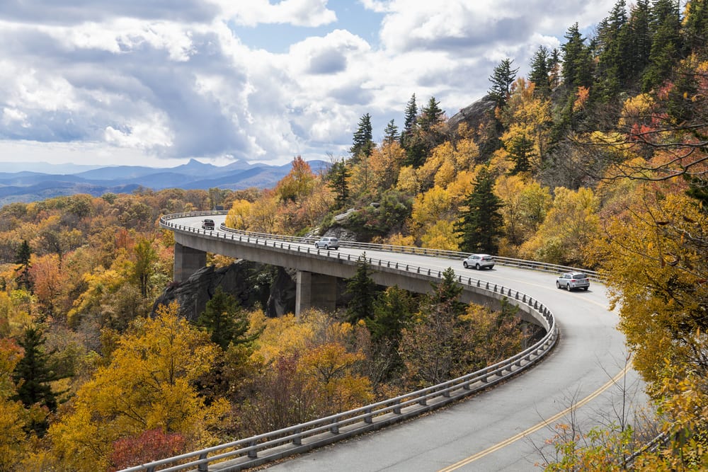 Cars drive over Linn Cove Viaduct, Blue Ridge Parkway in the Fall, NC