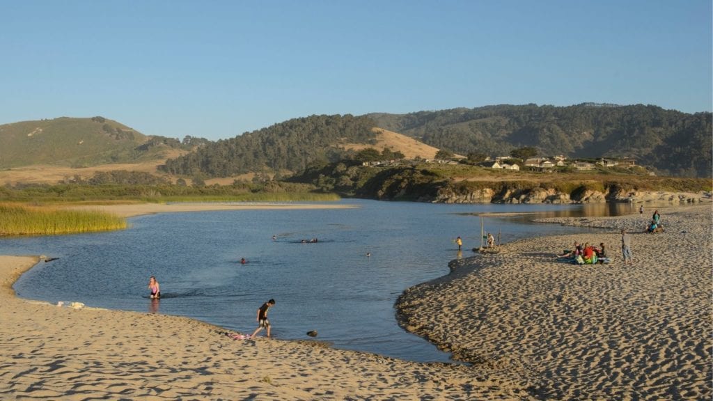 lagoon at Carmel River State Beach with people playing