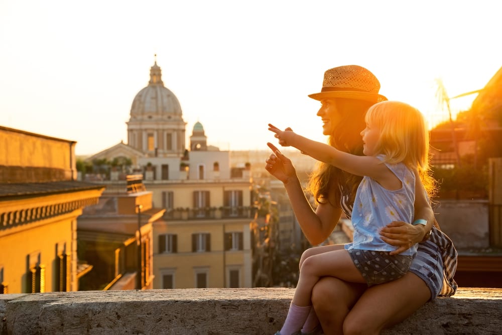 Mother and girl sitting on street overlooking rooftops of Rome (Photo: Shuttertock)
