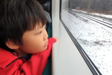 Little boy looking out a train window (Photo: @TYLim via Twenty20)