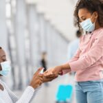 Teen girl and mother using hand sanitizer at the airport (Photo: Shutterstock)