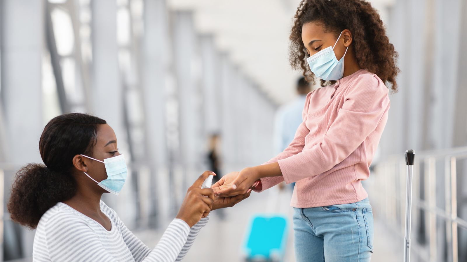 Teen girl and mother using hand sanitizer at the airport (Photo: Shutterstock)