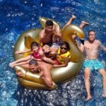 family floating in swimming pool relaxing
