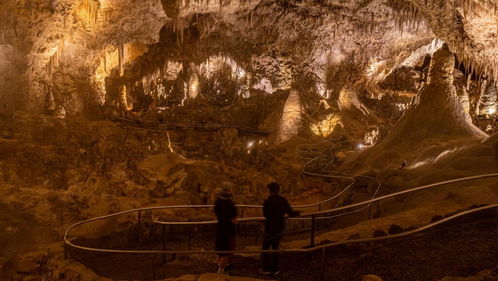 Two people on a walkway inside Carlsbad Caverns