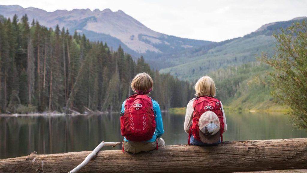 Kids wearing backpacks overlooking a lake (Photo: Osprey)
