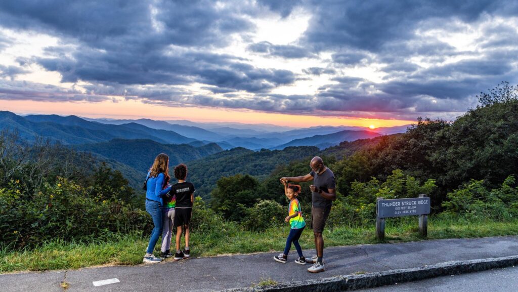 A family at Thunderstruck Overlook on the Blue Ridge Parkway at sunset in Asheville
