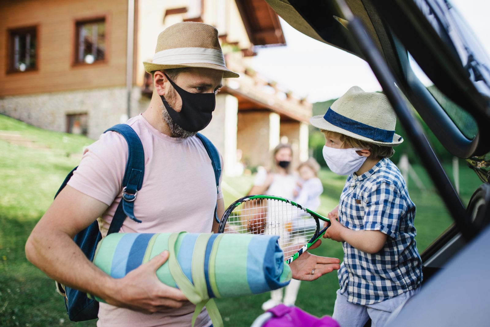 masked family packing a car to travel after the pandemic