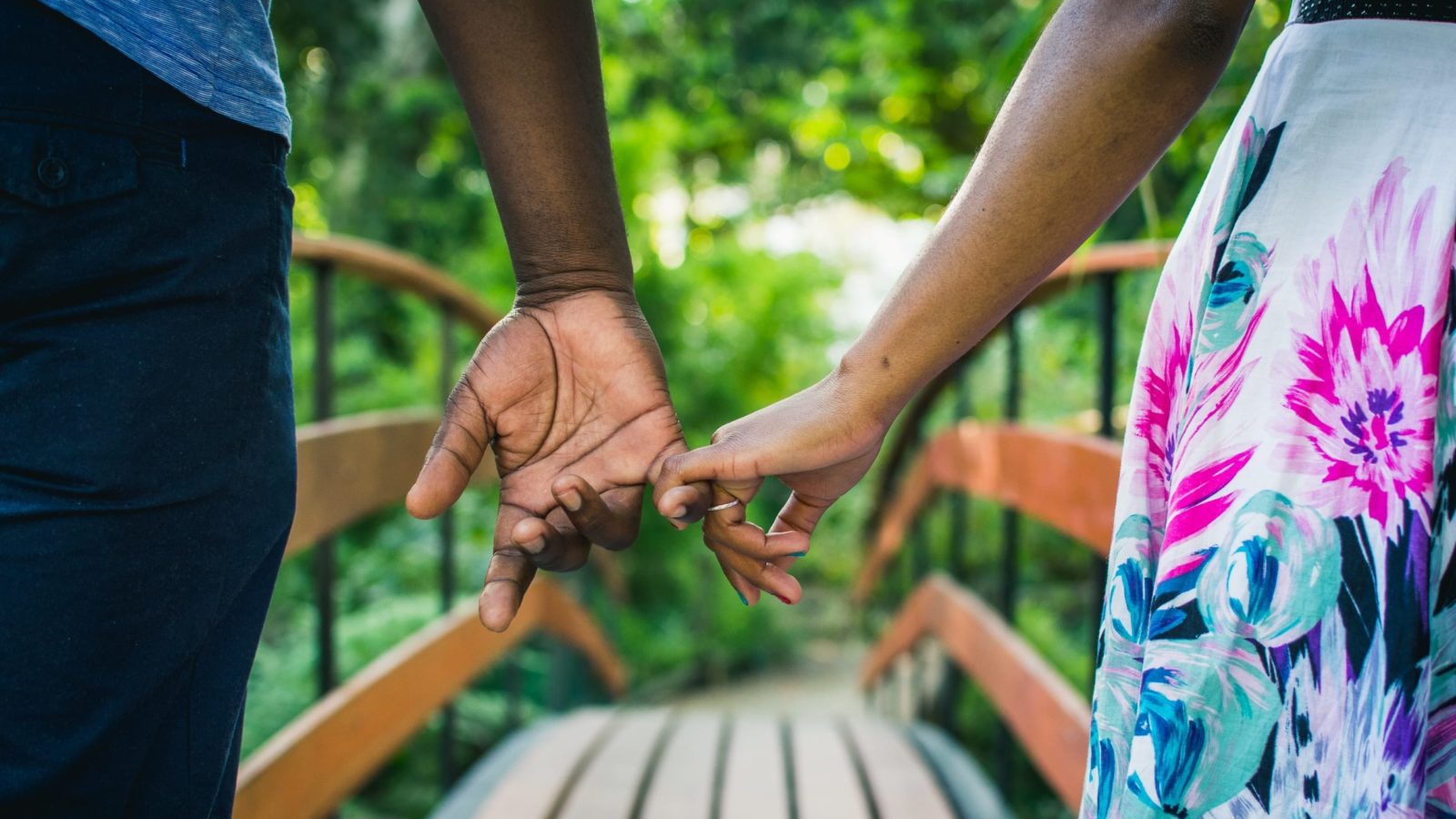 Holding hands while walking over a bridge: best vacation spots for couples