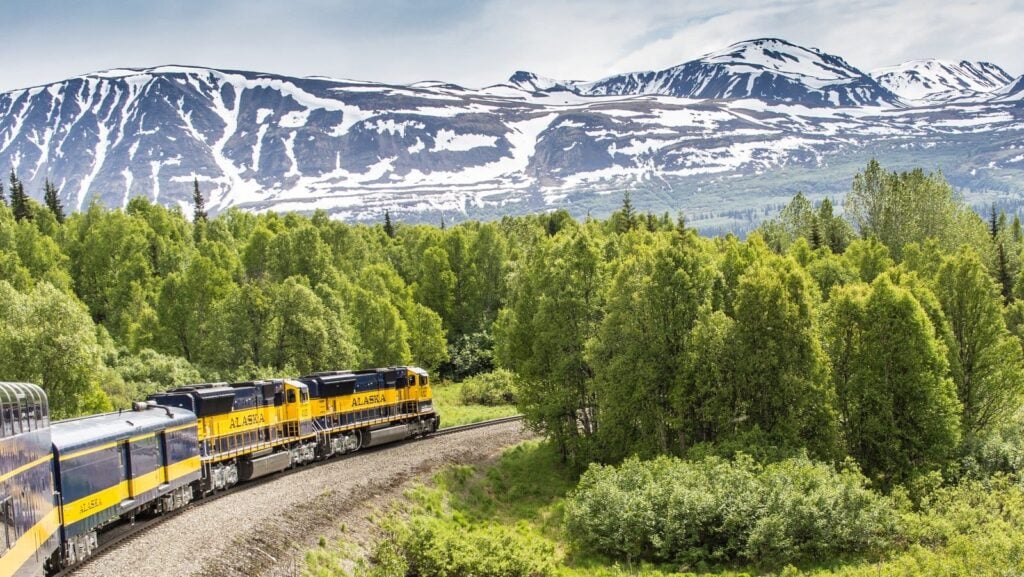 Alaska Railroad train with mountains in background of scenic train trip