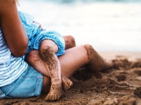 Mother breastfeeding child on the beach (Photo: Shutterstock)
