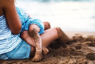 Mother breastfeeding child on the beach (Photo: Shutterstock)