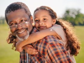 Happy grandfather giving a piggyback ride to his grandchild
