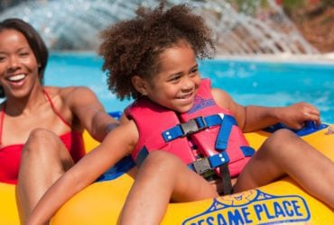 Child and parent floating down Rambling River at Sesame Place, an amusement park for young kids