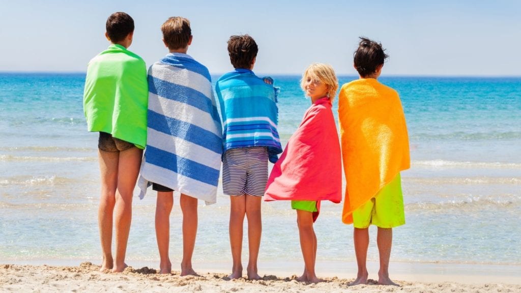 Kids drying off with beach towels after swimming (Photo: Sergey Novikov / Shutterstock)