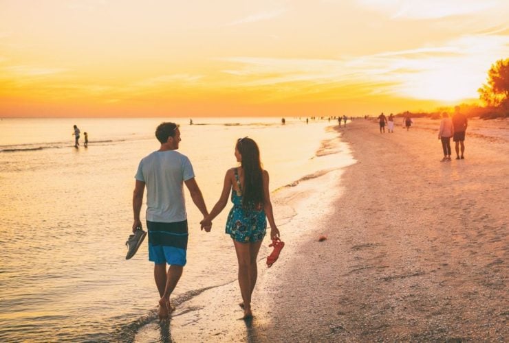 Couple walking together on one of their best family beach vacations (Photo: Shutterstock)
