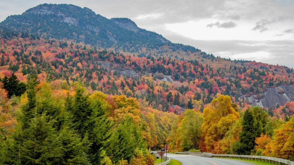 Blue Ridge Parkway dalam ide liburan musim gugur dengan latar belakang Grandfather Mountain