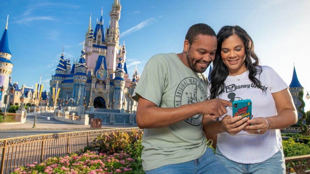 Guests using phone at Magic Kingdom in Orlando (Photo: Walt Disney World)
