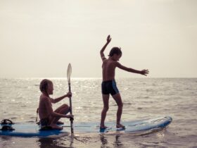 kids playing on a paddleboard in the water
