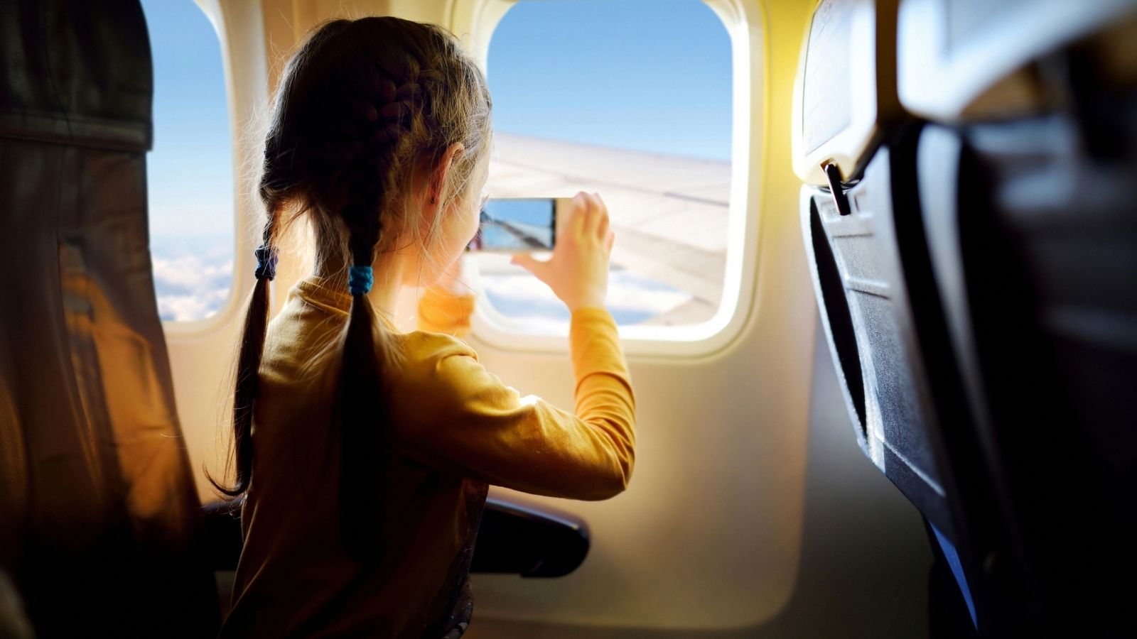 Child taking photo in airplane seat (Photo: Shutterstock)