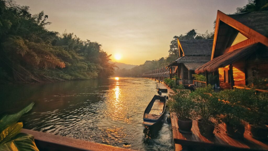 The idyllic River Kwai in Kanchanaburi. Shot at sunset with a longtail boat sailing in the river during a Trafalgar tour