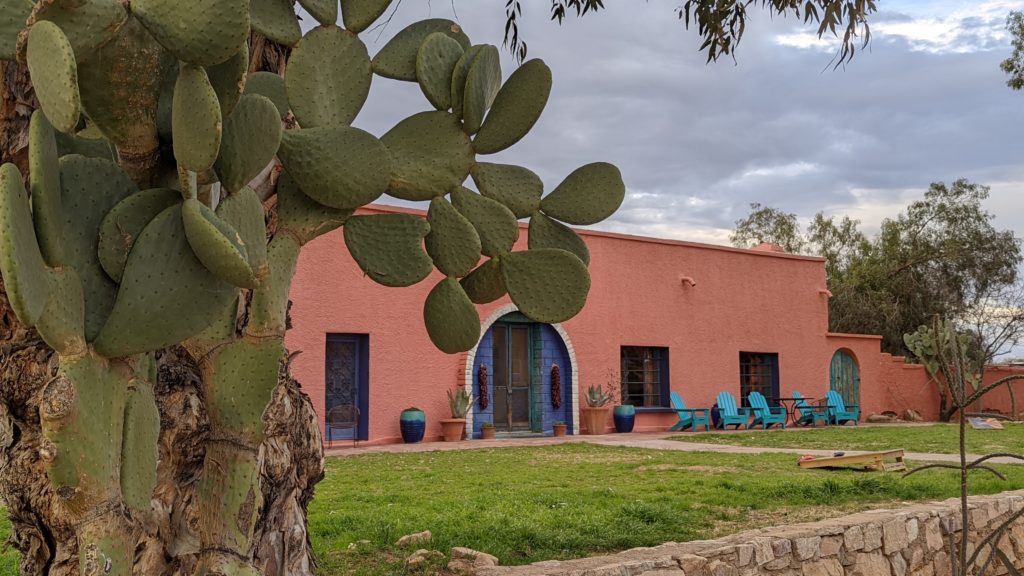 Edifici rosa amb cactus al Rancho de la Osa
