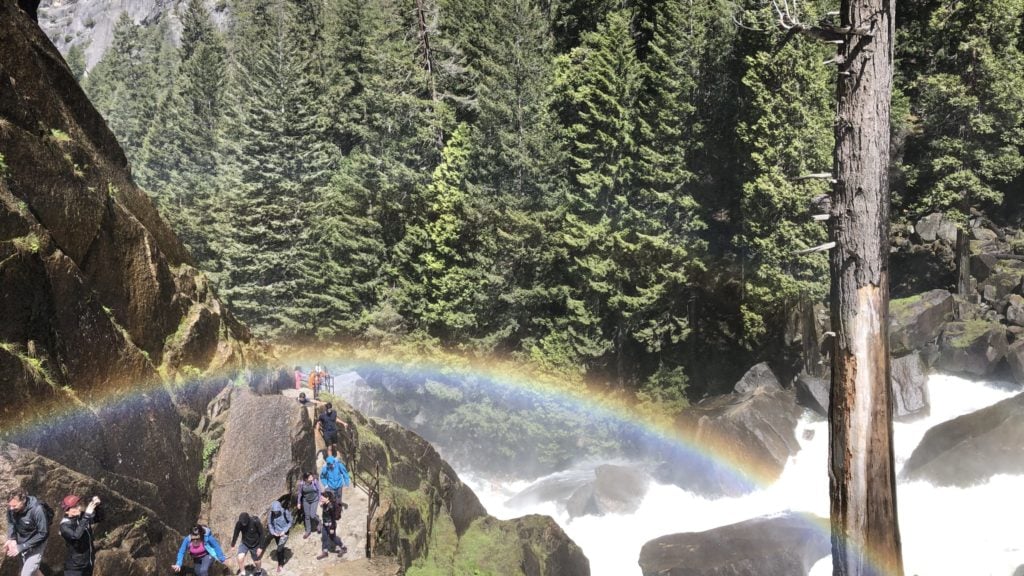 view of a rainbow over the mist trail on the vernal falls hike in yosemite valley