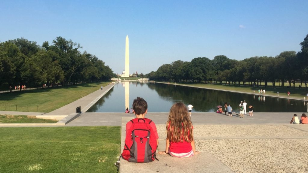 dua anak di National Mall di Washington, DC memandang ke arah Monumen Washington
