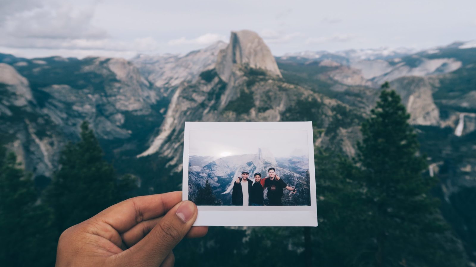 photo of a photo in front of a view of iconic U.S. attraction Yosemite National Park with Half Dome in the distance