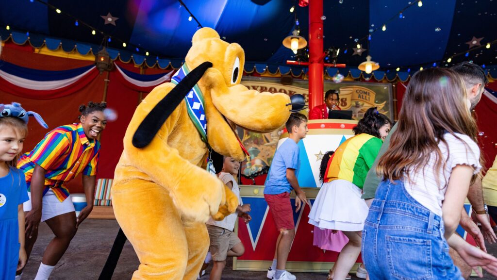 Pluto dancing and playing games with kids at Walt Disney World
