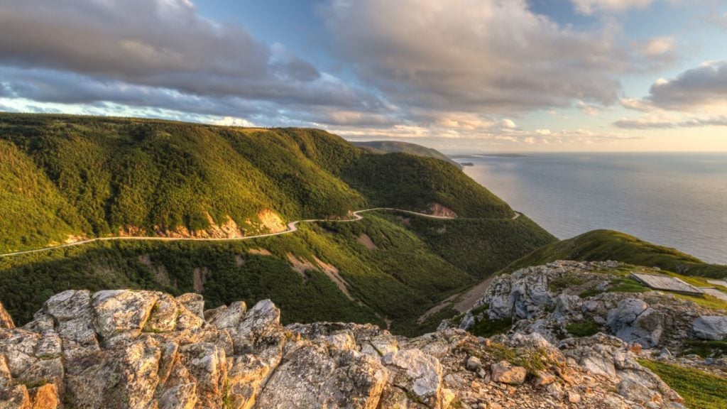 Jalan Cabot Trail yang berkelok-kelok terlihat dari ketinggian di Skyline Trail saat matahari terbenam di Taman Nasional Dataran Tinggi Cape Breton, Nova Scotia (Foto: Shutterstock)