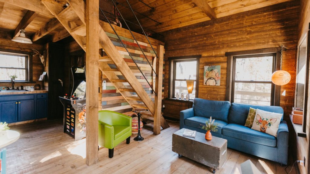 Living room, kitchen, and stairs at Tranquil Treehouse on Table Rock Lake