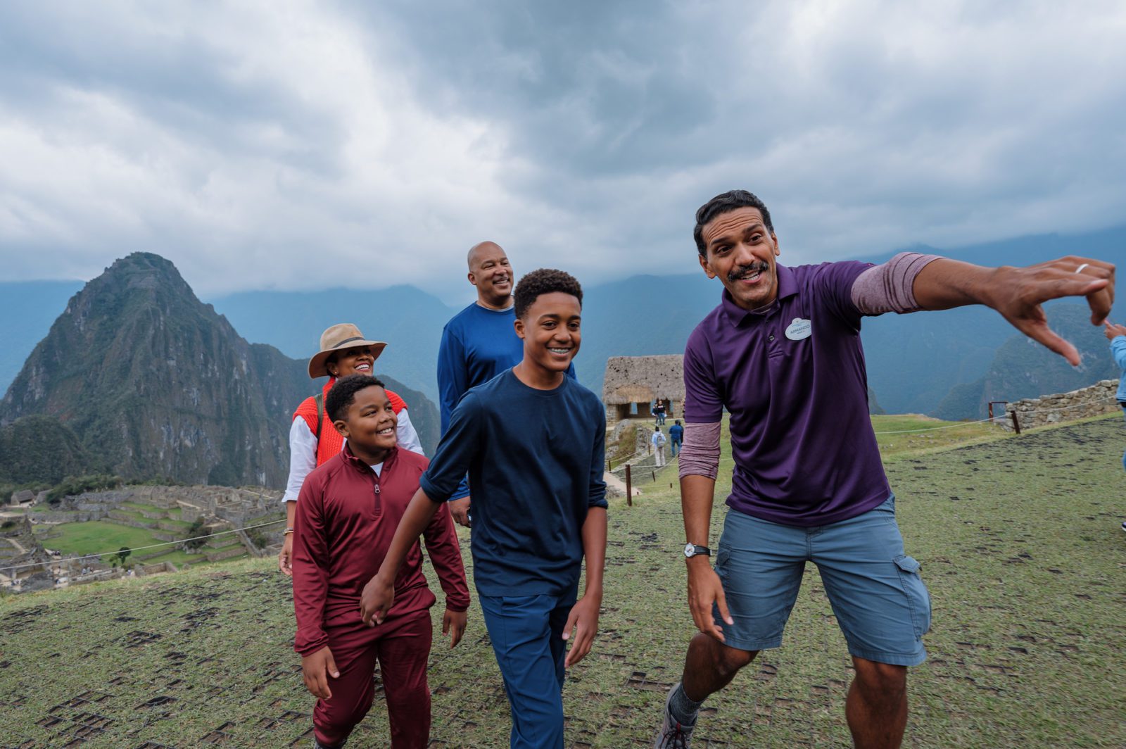 Adventures by Disney adventure guide showing a family the sights of Machu Picchu