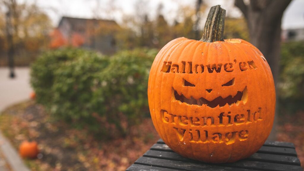 A carved pumpkin that says Halloween Greenfield Village