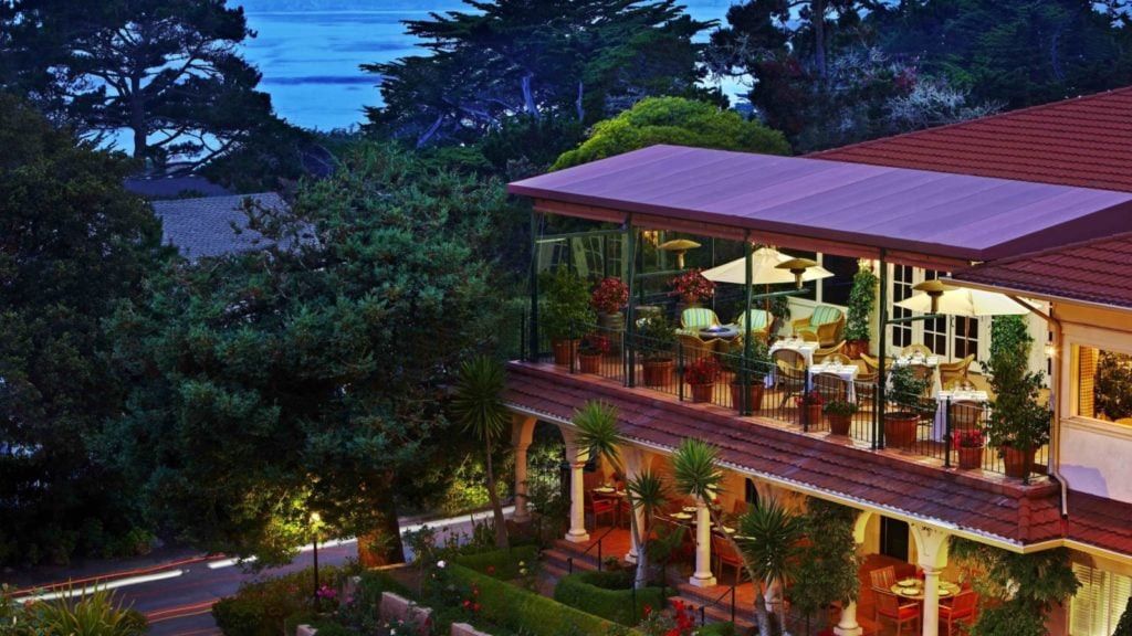exterior dusk view of La Playa Carmel, with view of cypresses and the Pacific in the background in Carmel, a romantic getway in California