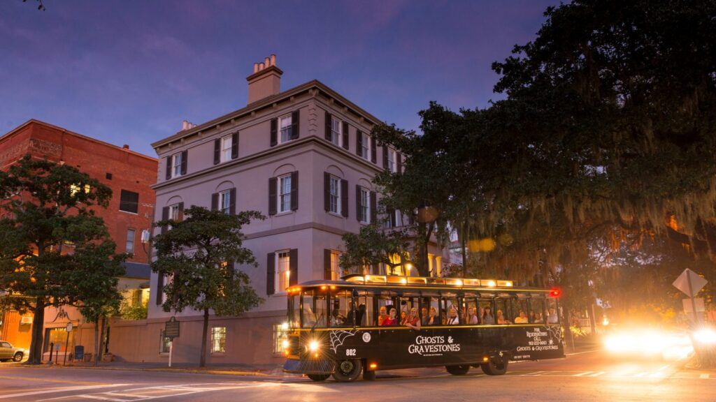 A ghost tour trolley driving through Savannah, Georgia at night