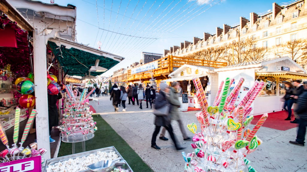 Pasar Natal di Jardin des Tuileries dengan kios penjual dan orang-orang berjalan